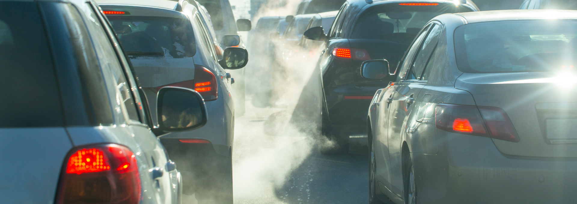 Verschmutzung durch die Abgase von Autos in der Stadt im Winter. Abgase von Autos an einem kalten Wintertag.