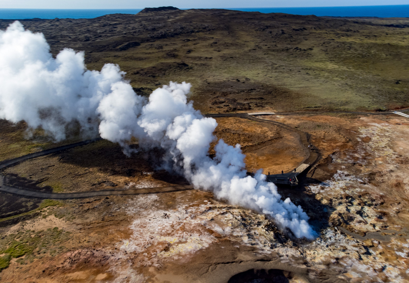 Luftaufnahme eines geothermischen Gebiets in Island mit Dampfquellen und heißen Quellen, umgeben von farbenprächtiger Minerallandschaft