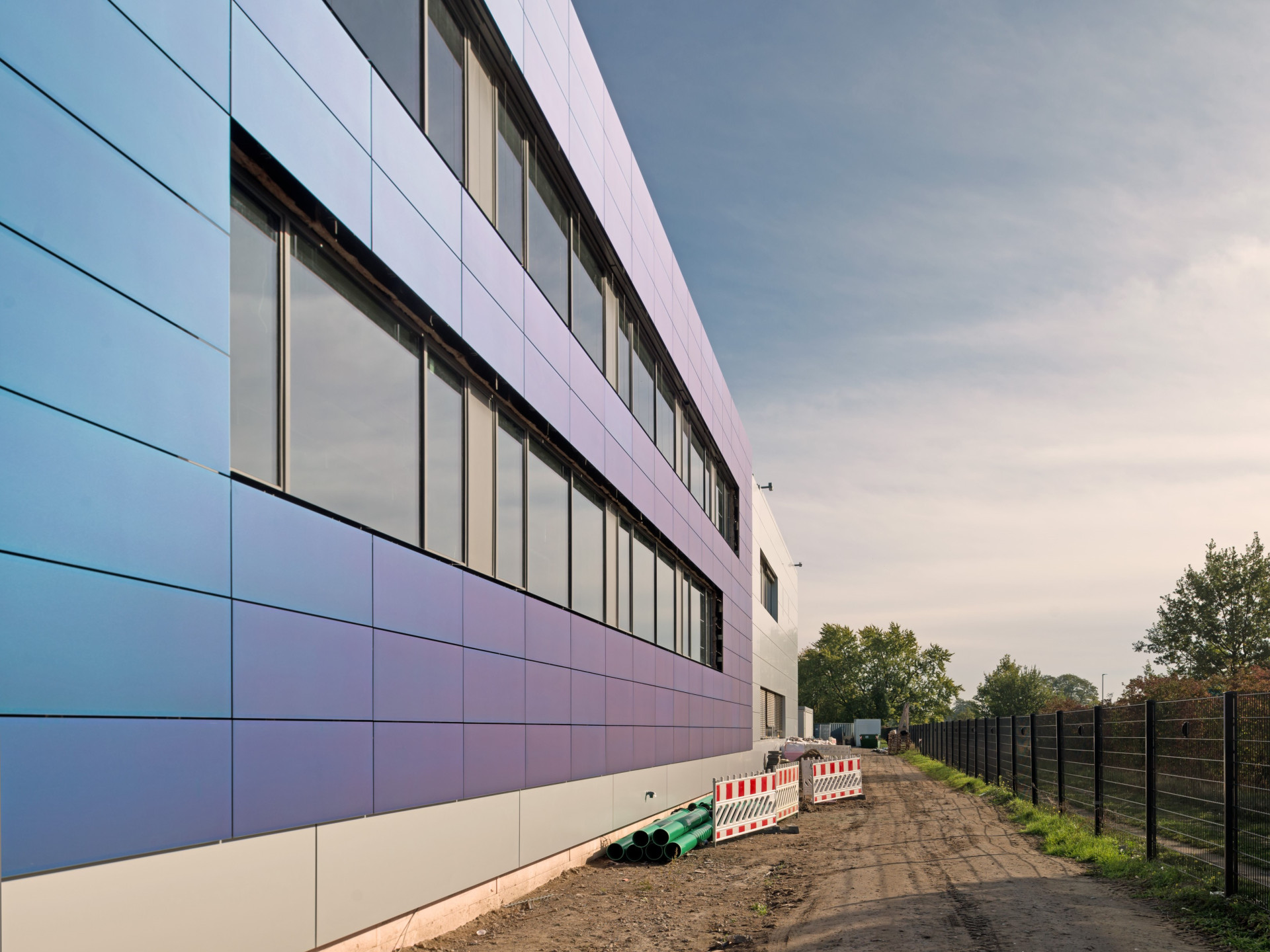 blaue Solarzellenpanele an der Fasse einer Produktionshalle 