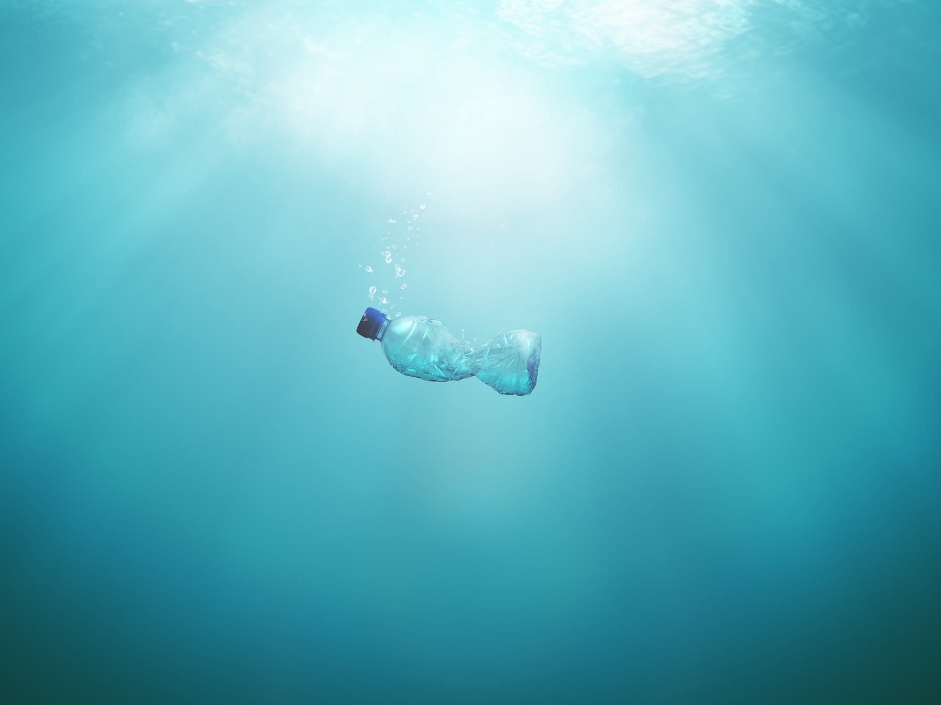 Plastikflasche schwimmt im blauen Wasser