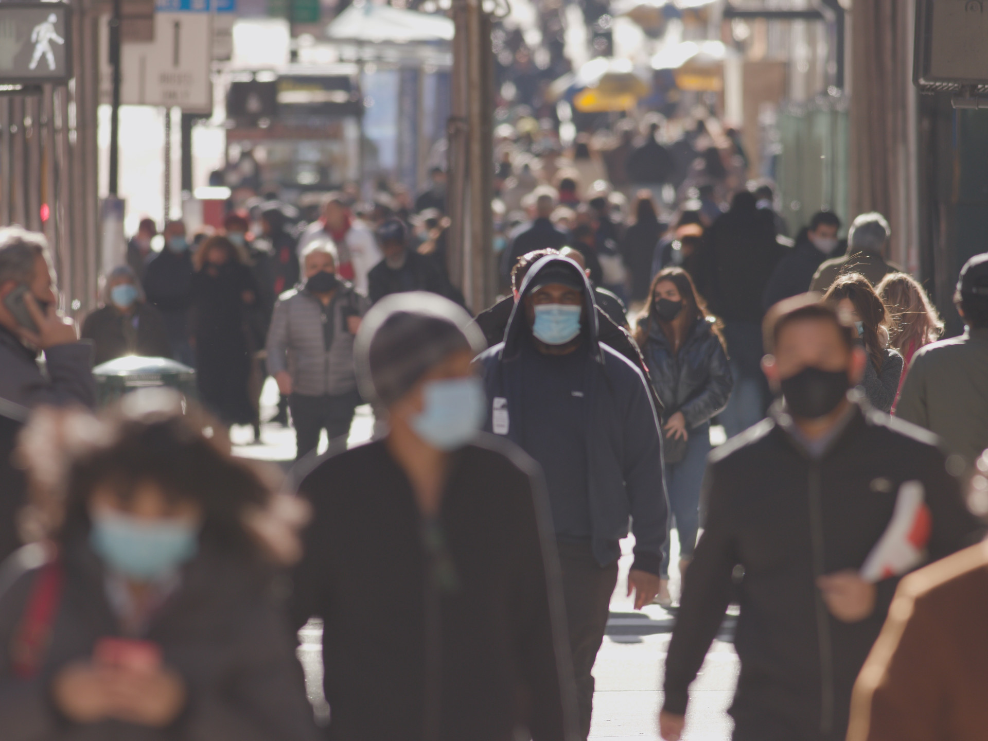 Anonyme Menschenmenge mit hygienischen Masken in einer Großstadt