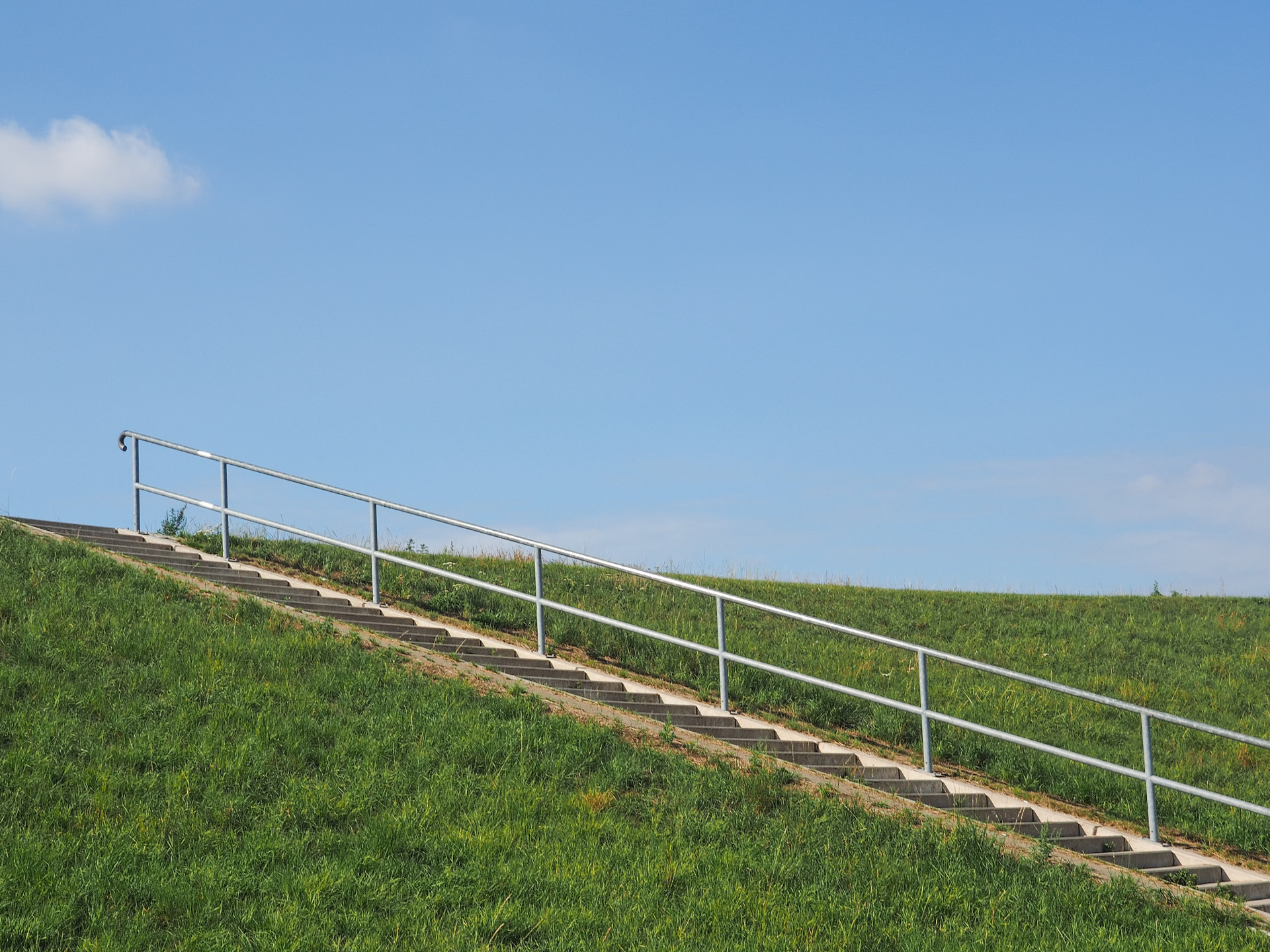 Eine Treppe führt auf einen Deich hinauf