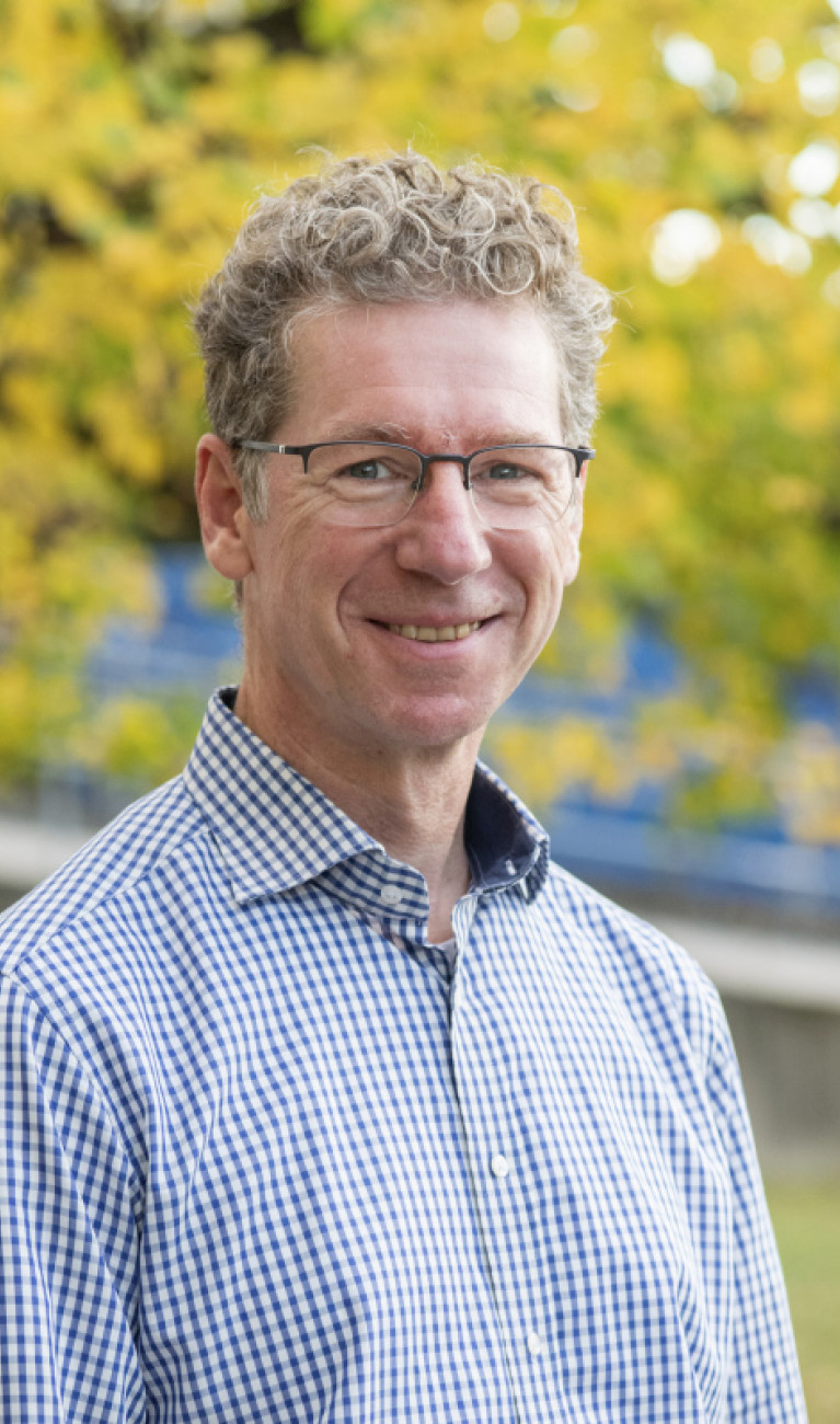 Portrait des Wissenschaftlers vor einem Baum im Herbst