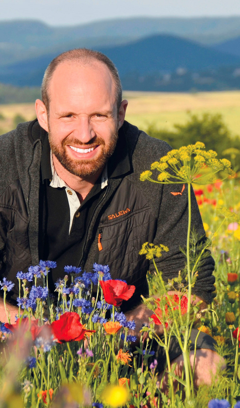 Yves Zinngrebe in einem Wildblumenfeld