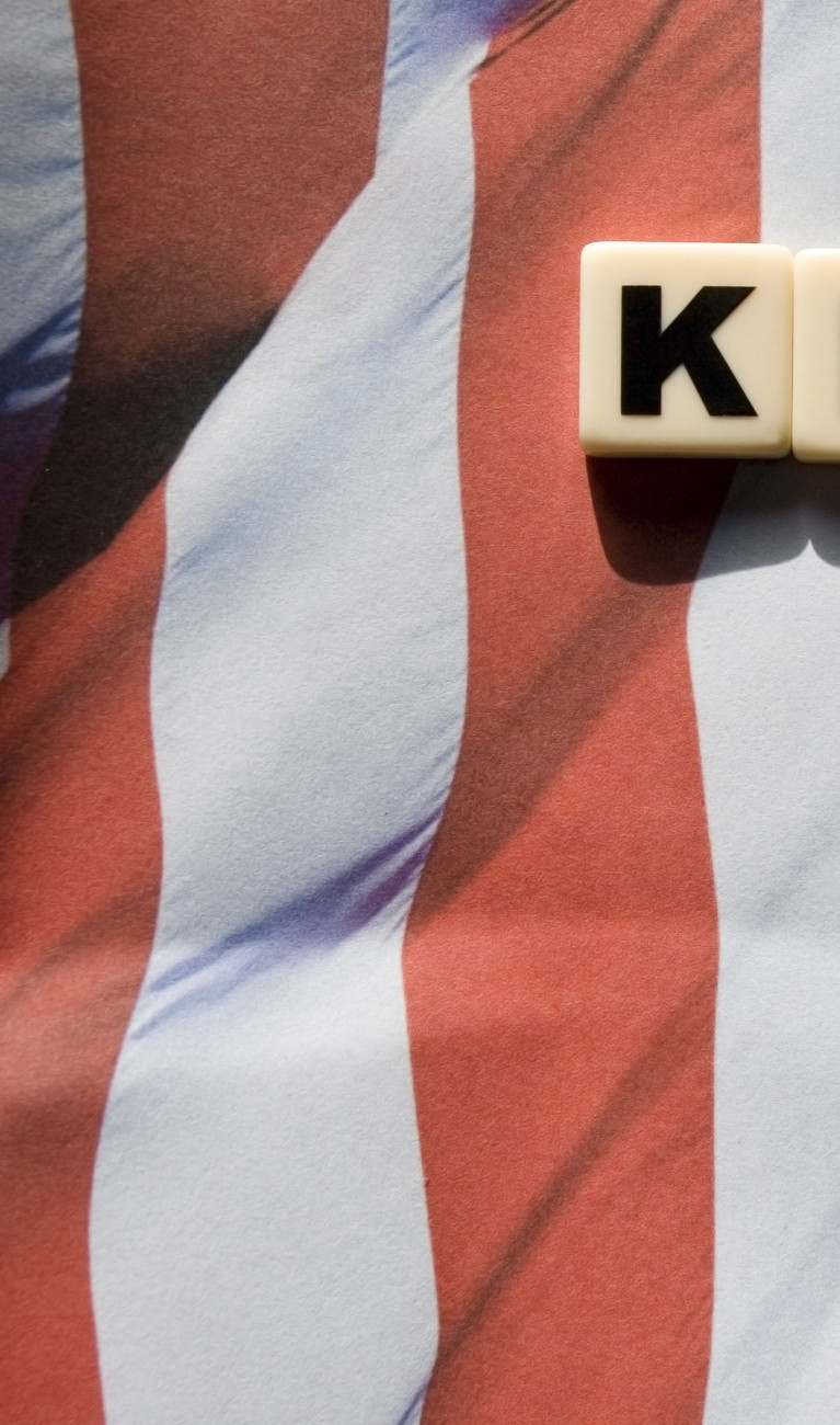 Amerikanische Flagge auf der in Buchstabenwürfel das Wort "Klimawandel" steht