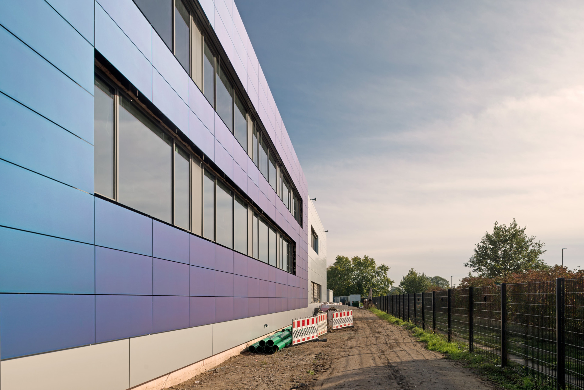 blaue Solarzellenpanele an der Fasse einer Produktionshalle 