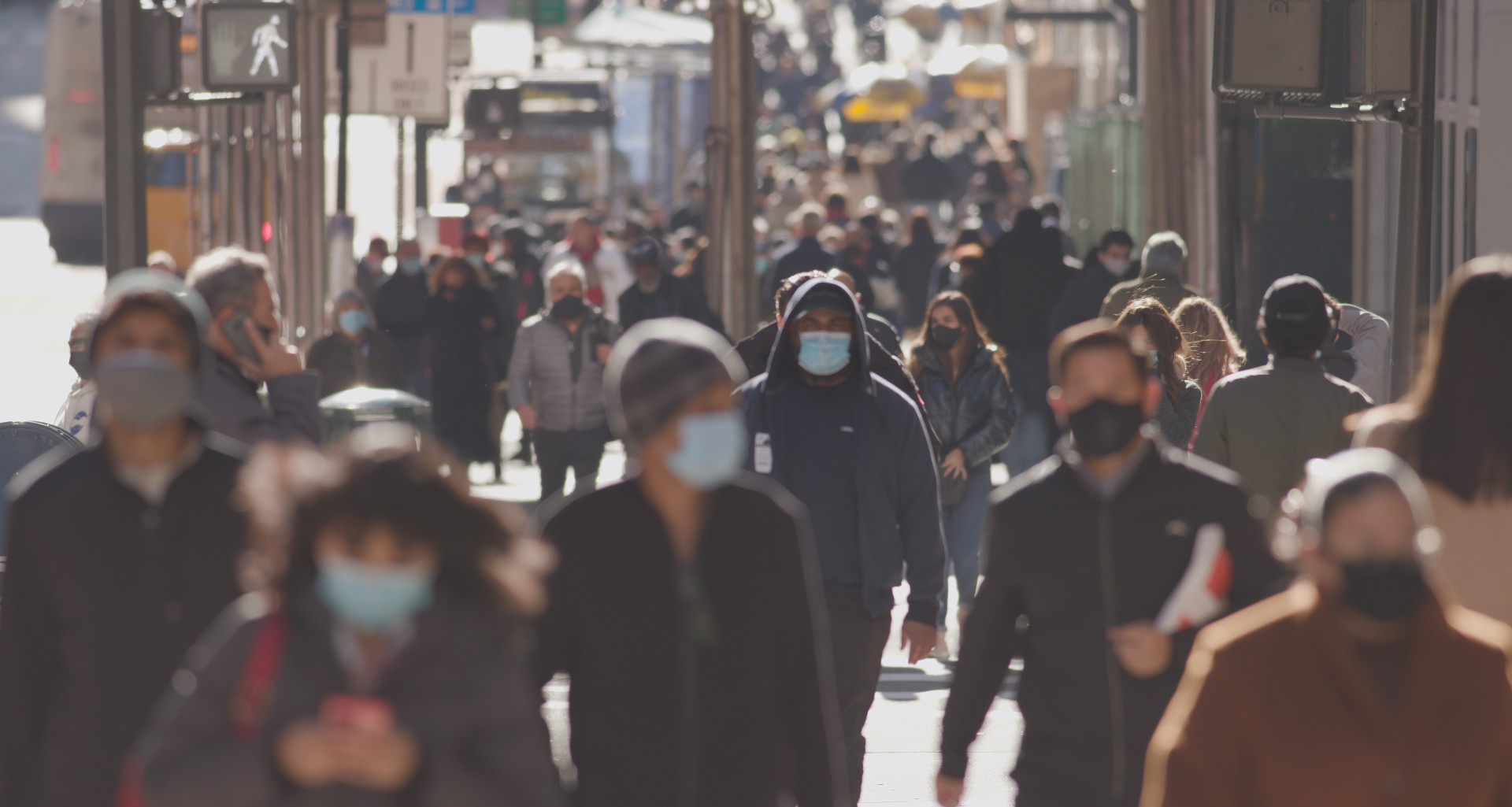 Anonyme Menschenmenge mit hygienischen Masken in einer Großstadt