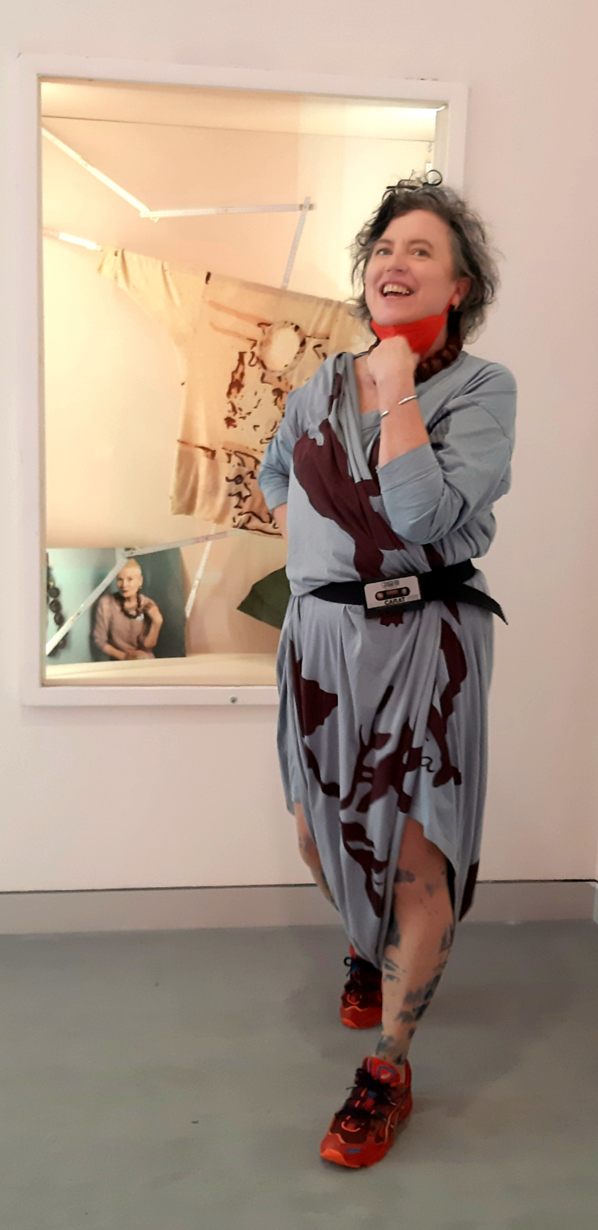 Die Designerin M. Glomb steht vor einem Spiegel und trägt ein selbstentworfenes Kleid