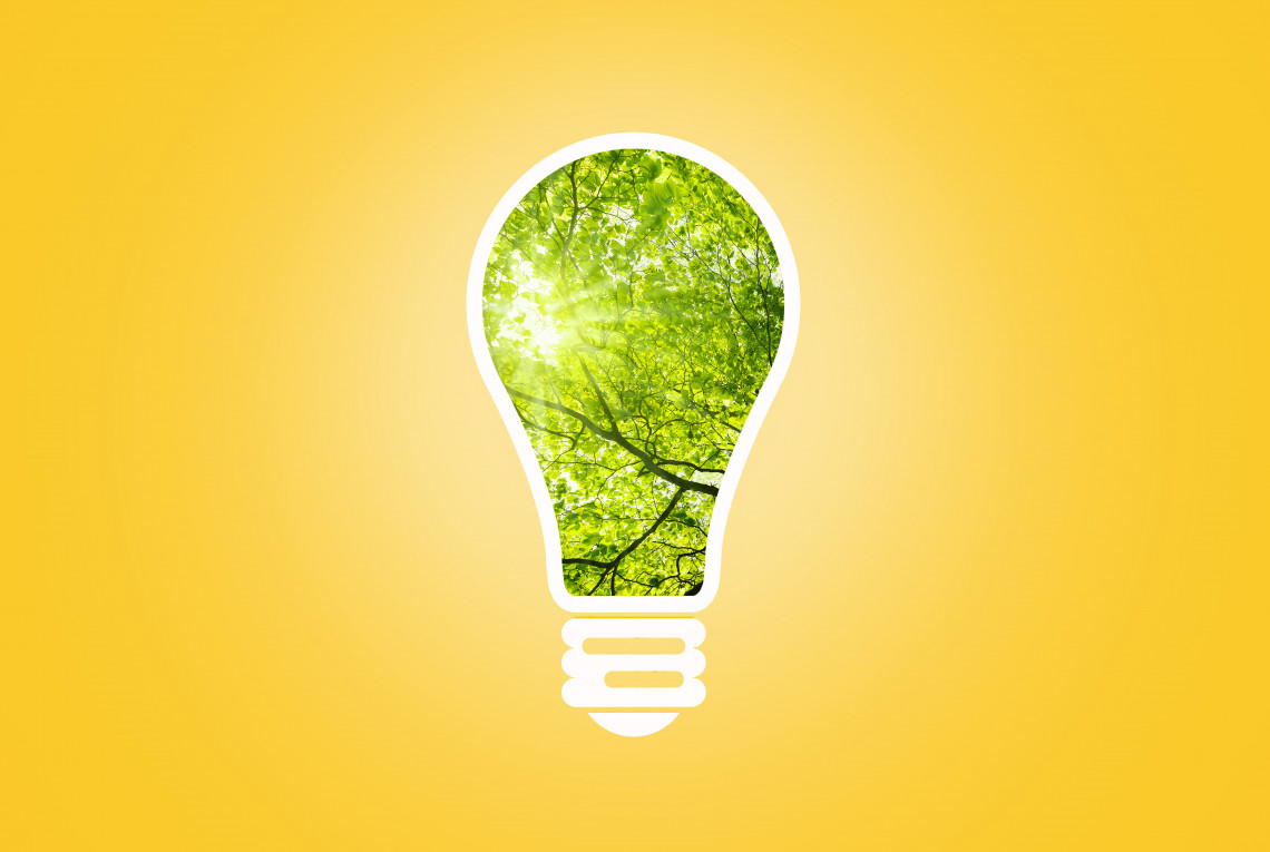 Green light bulb with yellow background