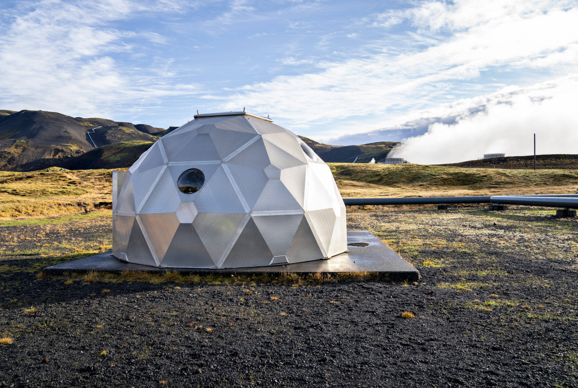 Carbon Capture (Island) Silbernes Iglu in karger Landschaft, mit Dampf im Hintergrund