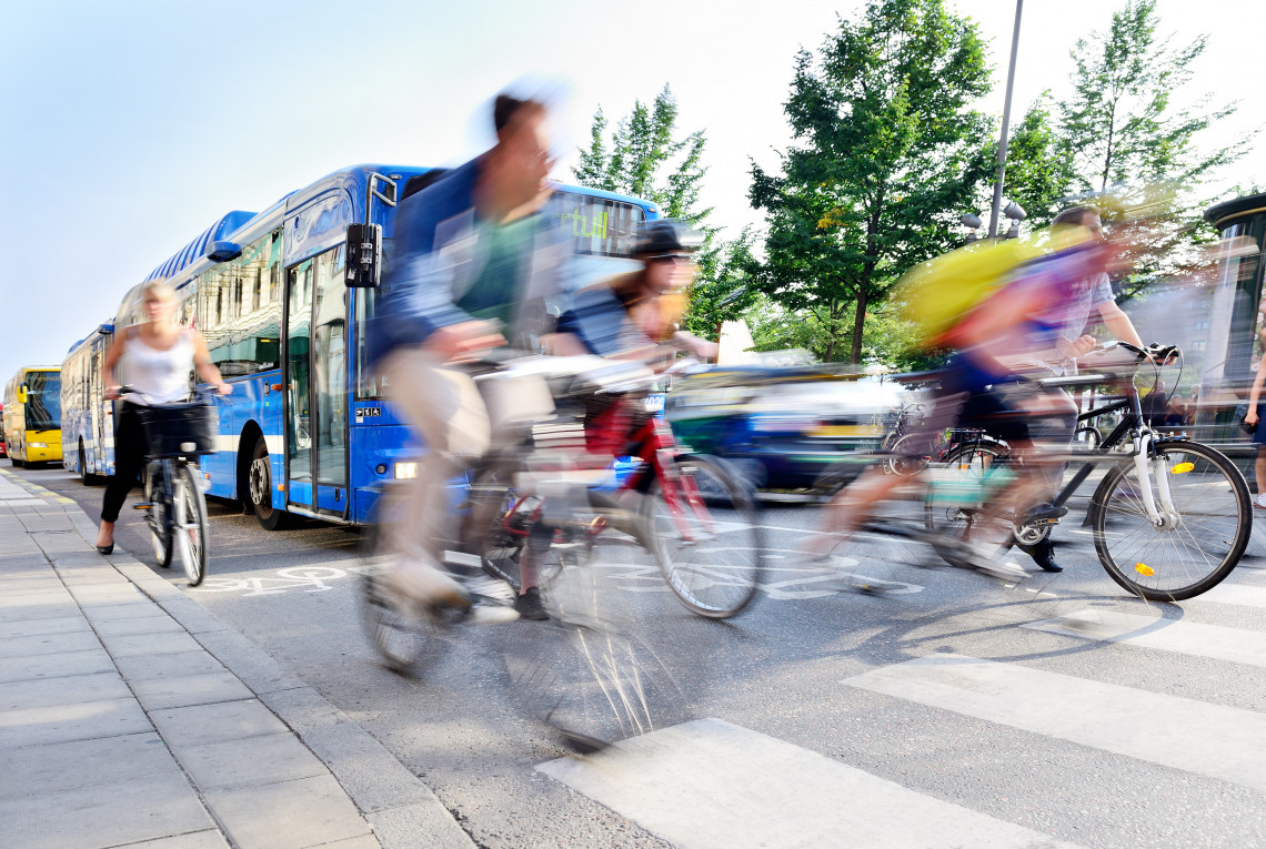 Radfahrer, Busse, Autos und Zebrastreifen im Straßenverkehr