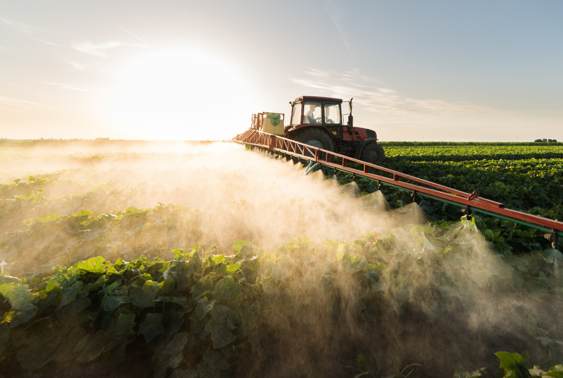 Traktor und Düngemittel Ein Traktor bringt Düngemittel auf einem Feld aus.