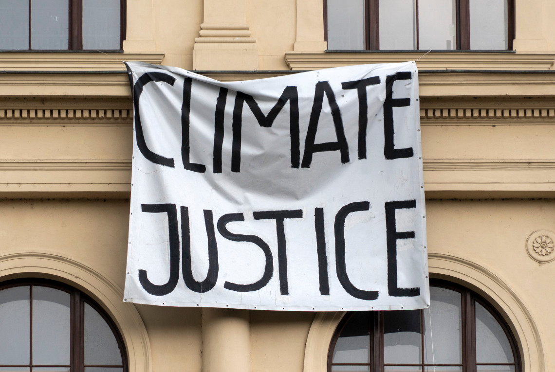 Klimagerechtigkeit Banner für Klimagerechtigkeit vor einem Gebäude