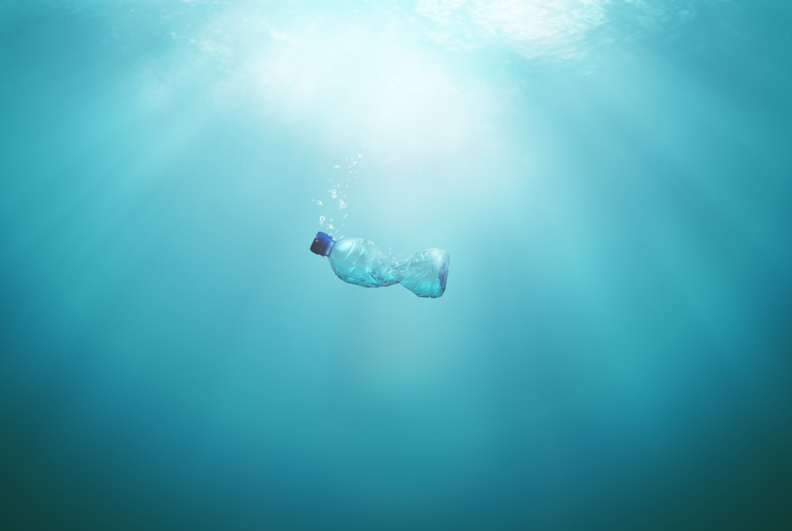 Plastikflasche schwimmt im blauen Wasser
