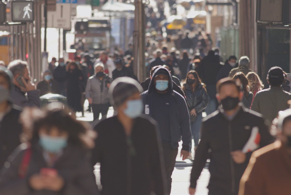 Anonyme Menschenmenge mit hygienischen Masken in einer Großstadt