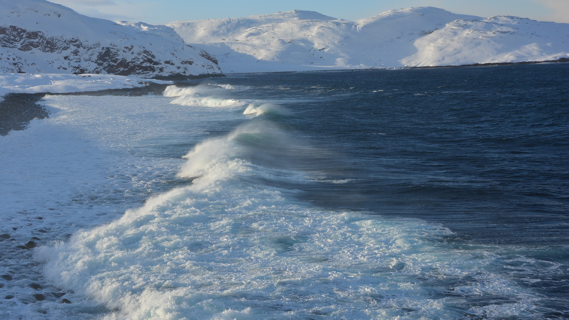A coastline with ocean and snow-capped mountains